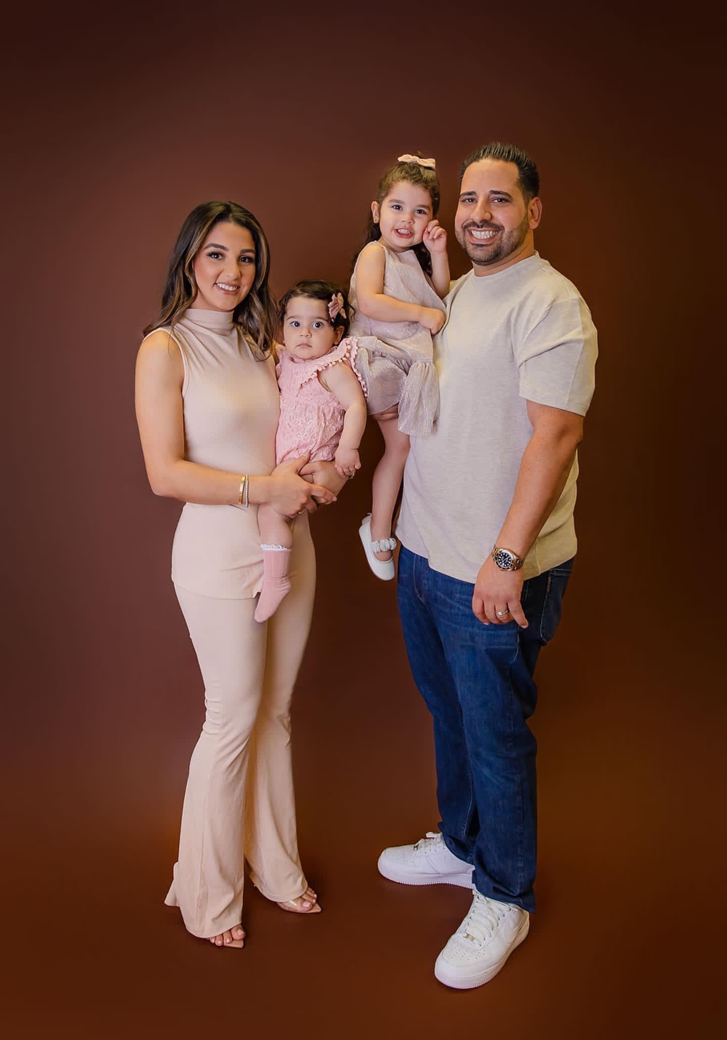 Founder of Mind Your Beeswax and her family, in front of a red backdrop 